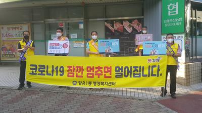 장유1동 장유신도시연합청년회 회원들이 코아상가 일원에서 시민들에게 '잠깐 멈춤 캠페인' 동참을 홍보하고 있다.